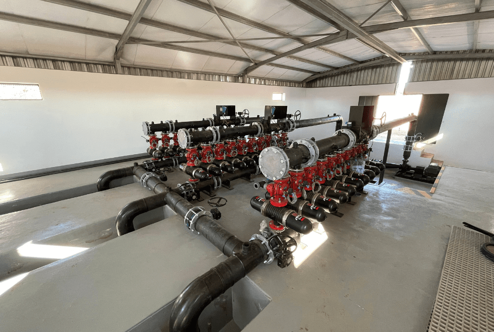 Interior of a pump house showcasing installed pipes, pumps, and fittings
