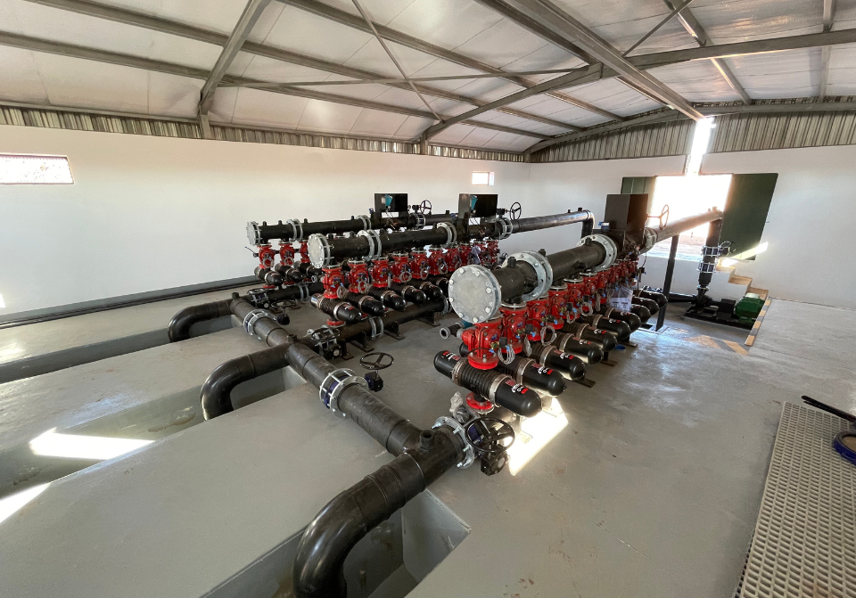 Interior of a pump house showcasing installed pipes, pumps, and fittings